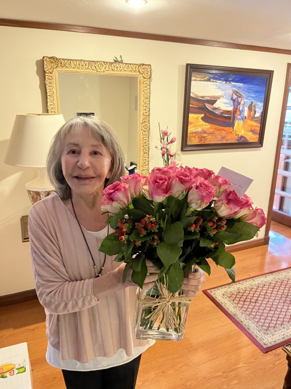 cliente feliz con un florero de rosas rosadas